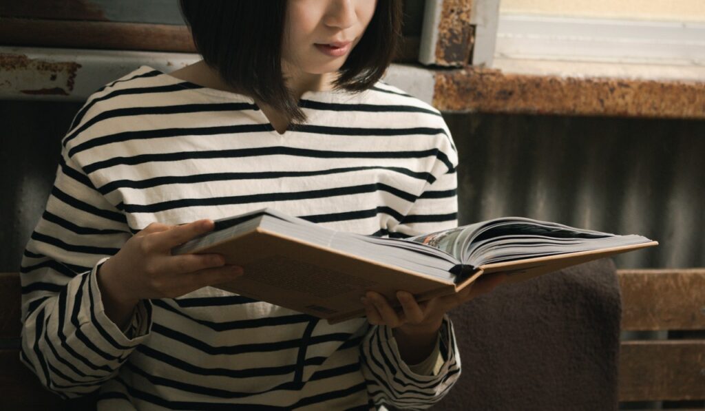 カフェで写真集を眺める女性の写真素材