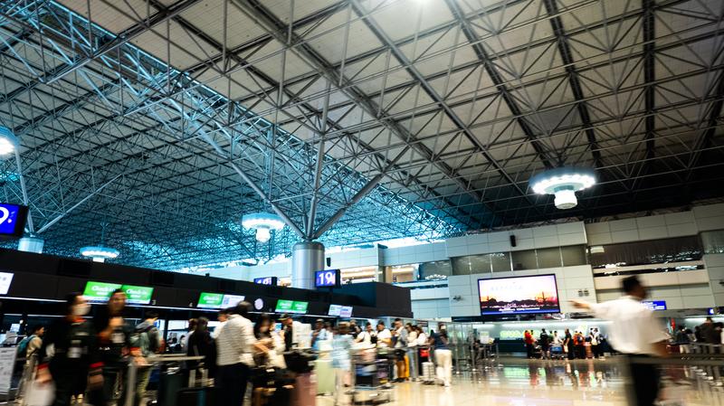 チェックインカウンター前で手続きを待つ人々の無料の写真素材