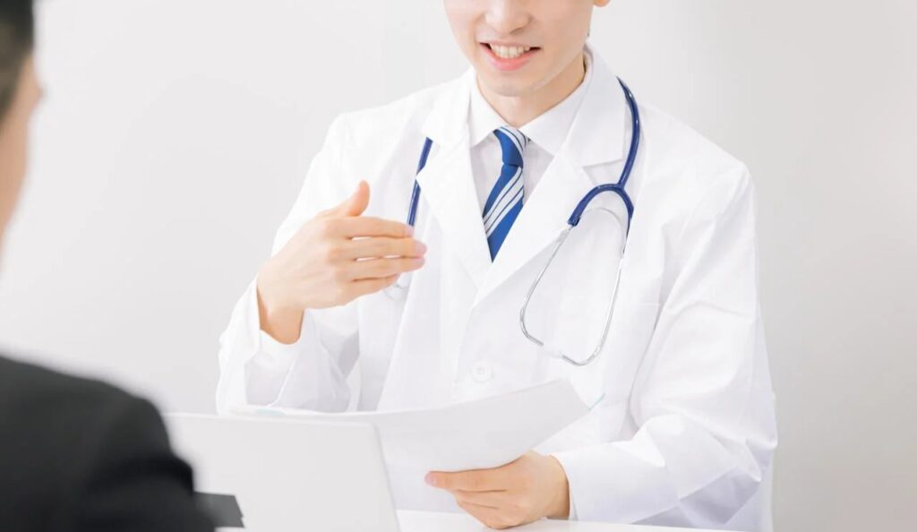患者に医療アドバイスを提供する若い医師の笑顔の無料の写真素材