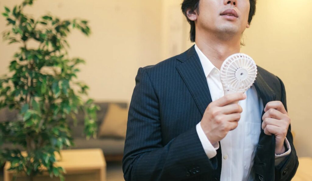 ハンディ扇風機を使用する営業マンの無料の写真素材